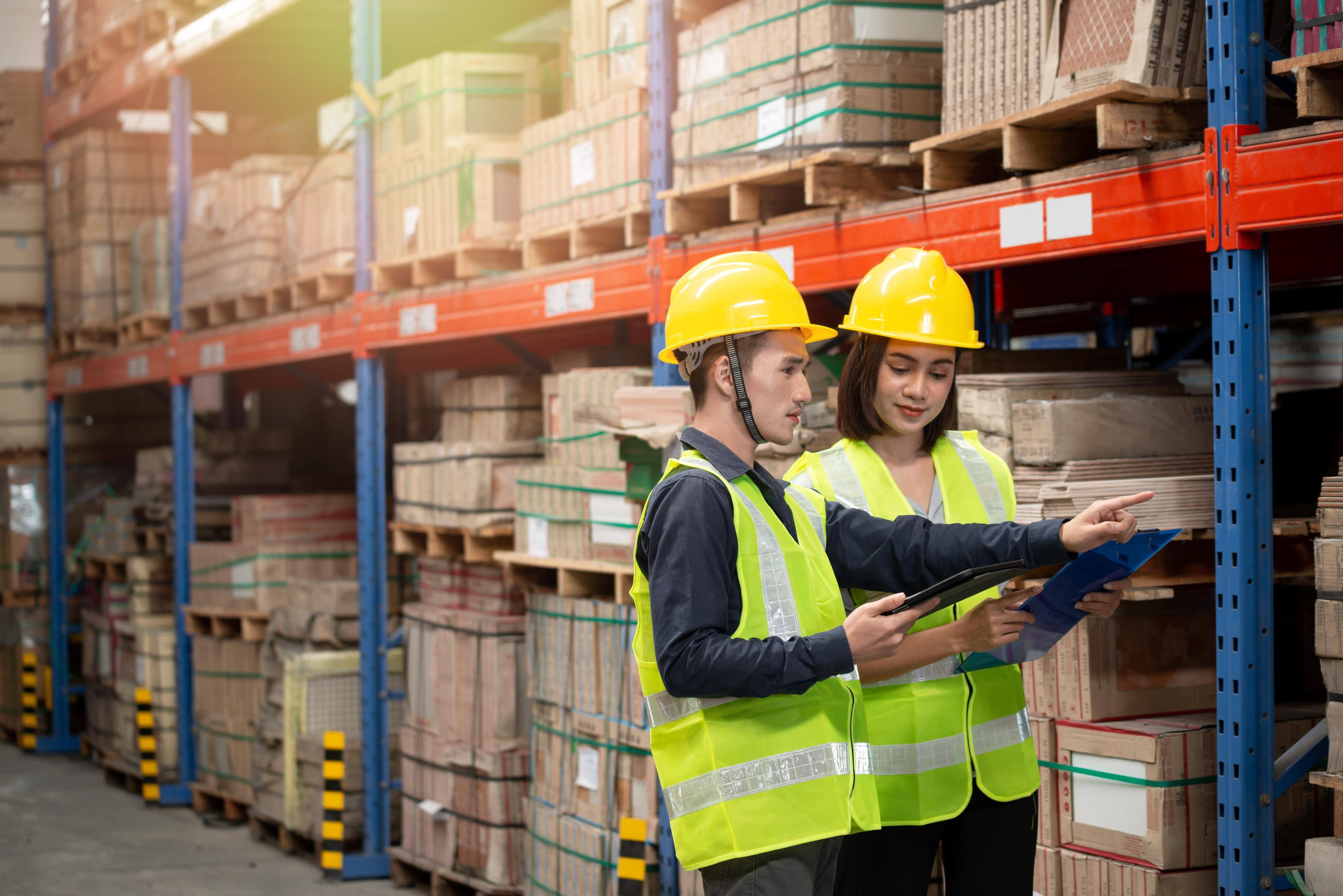 two warehouse employees reviewing inventory
